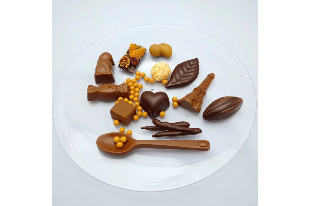 白い皿に並べた、さまざまな形のミルクチョコレートとビターチョコレート